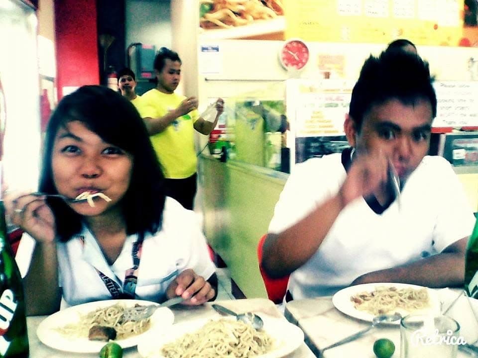 Sam and Angela in white school uniforms eating spaghetti at a restaurant
