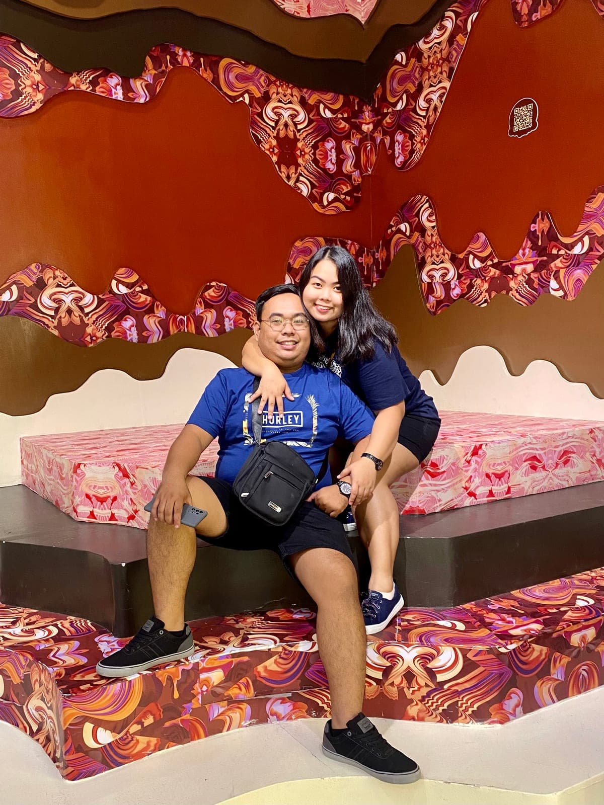 Sam and Angela posing in a colorful candy-themed photo room