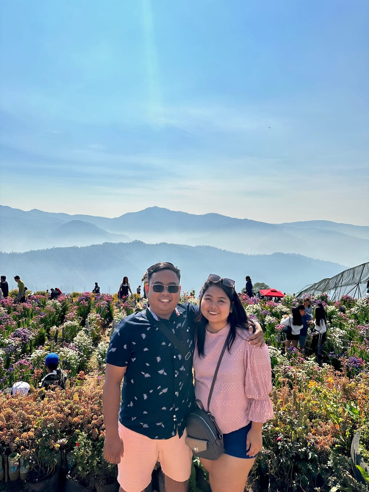 Sam and Angela in a flower garden with misty mountains behind them