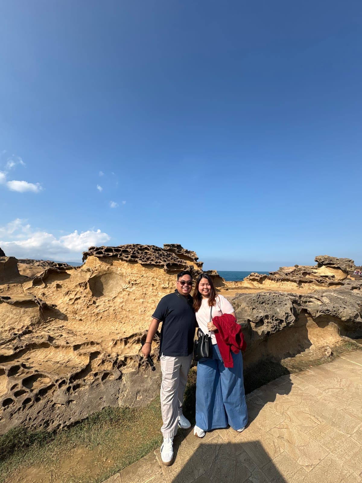 Sam and Angela standing among weathered seaside rock formations